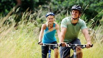 Happy couple riding bicycles outside, healthy lifestyle fun conc