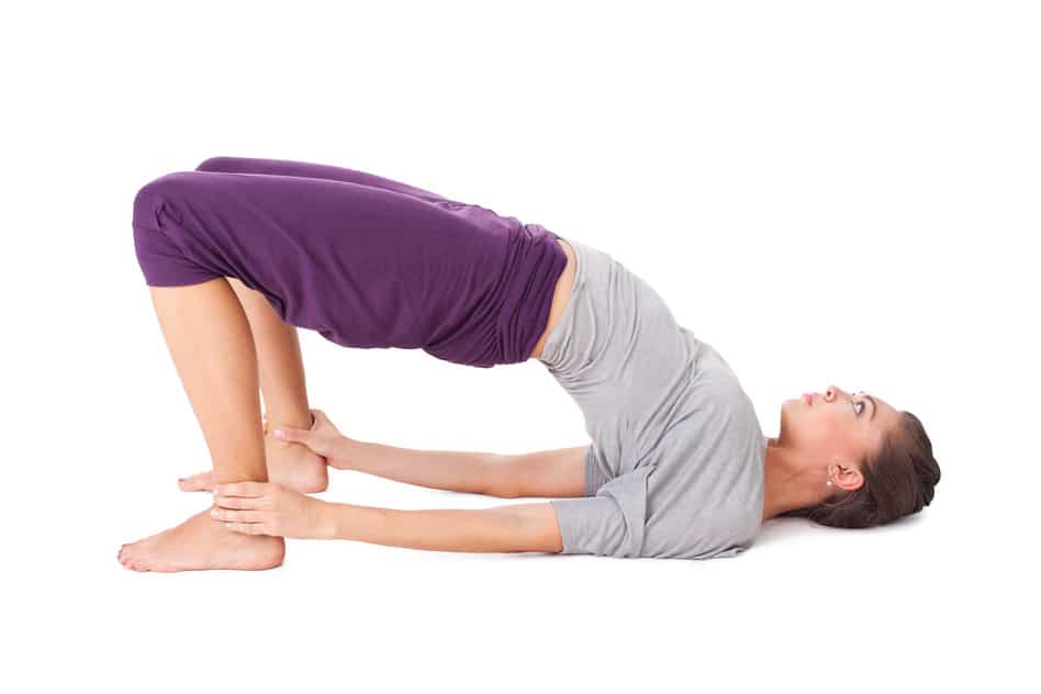Young woman doing yoga exercise bridge pose. Isolated on white background